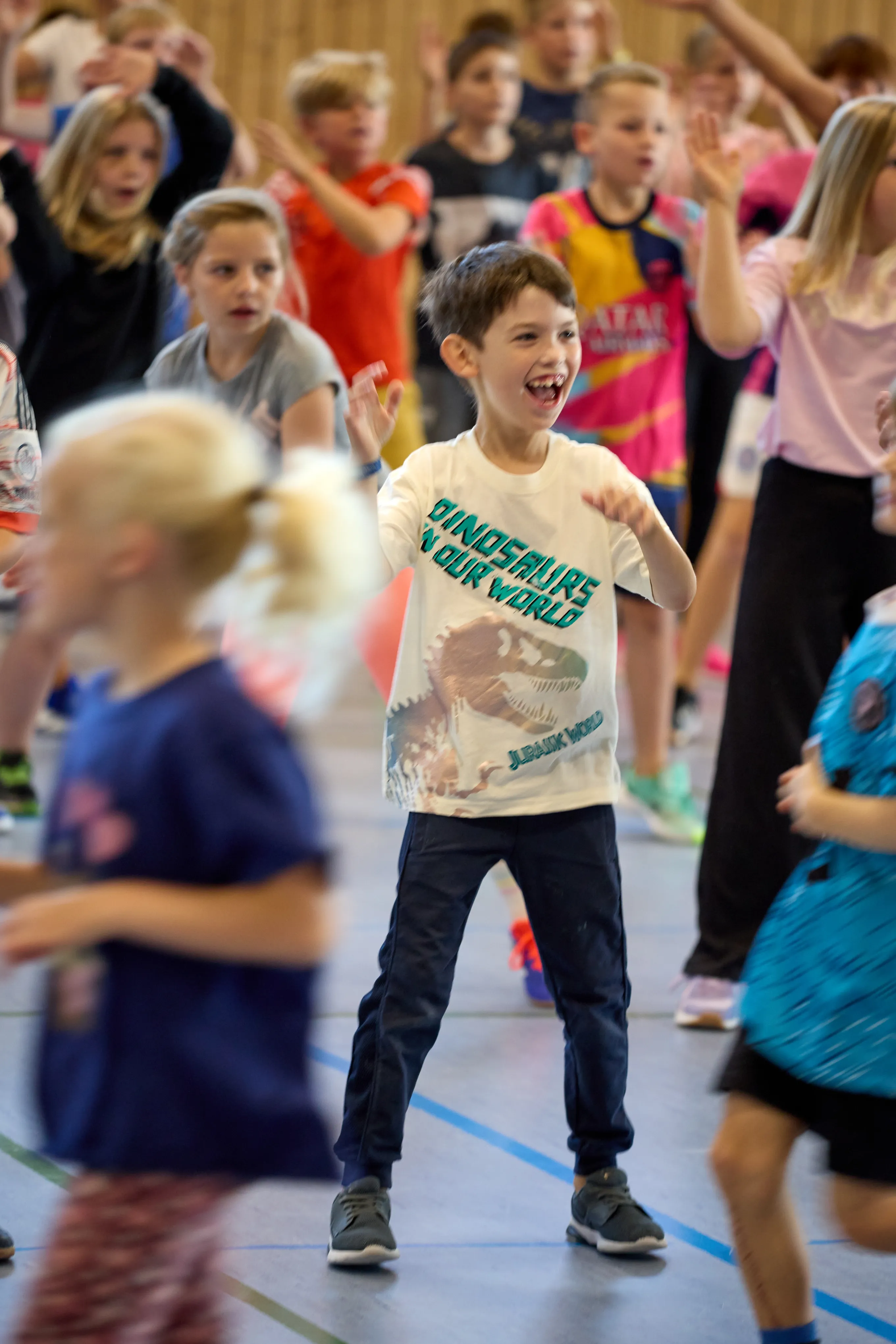 Lachender Junge tanzt beim LeTaBe-Projekt in der Sporthalle